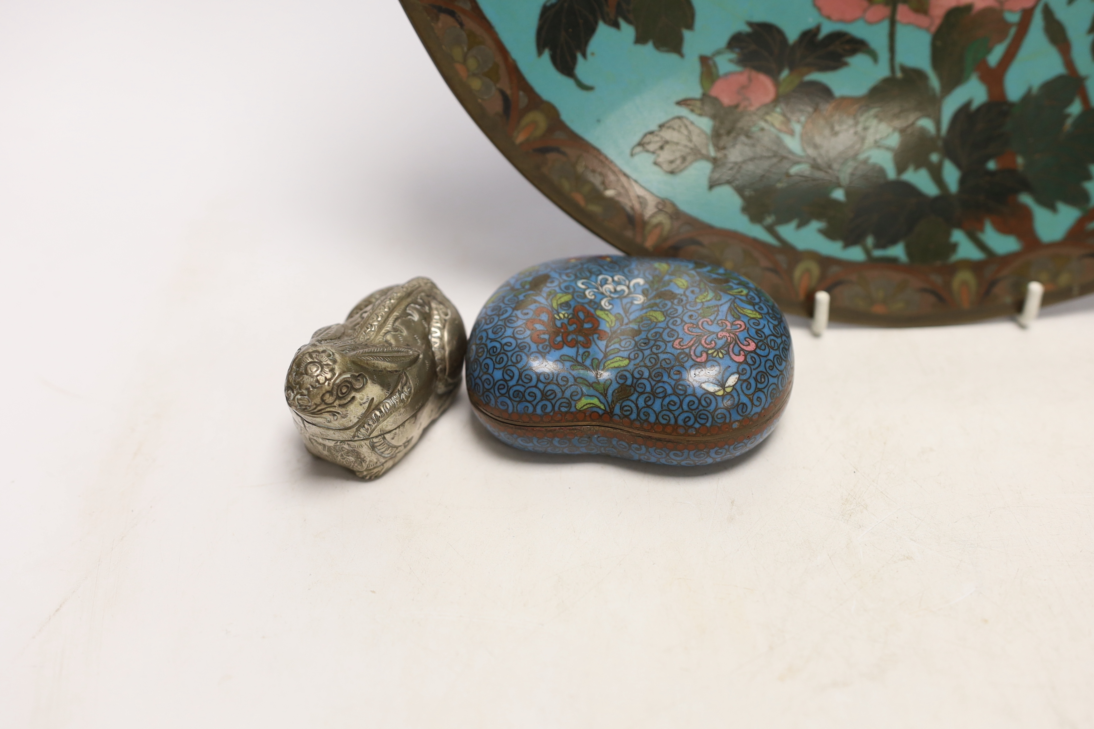 A Chinese cloisonné enamel kidney shaped box and cover, a pewter bottle and white metal ‘rabbit’ box and cover, and a Japanese cloisonné enamel dish, largest 30cm in diameter